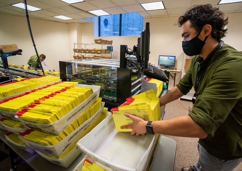 (Rick Egan  |  The Salt Lake Tribune)   Carson Adams prepares primary election ballots for counting at the Salt Lake County Government Center on Wednesday July 1, 2020.