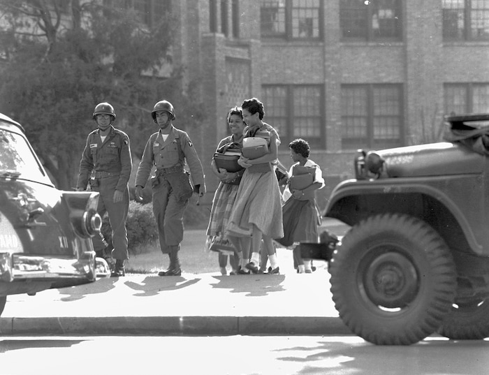 FILE - In this Sept. 27, 1957, file photo, two paratrooper officers escort black students from Central High School in Little Rock, Ark. School was closing for the weekend. (AP Photo/File)