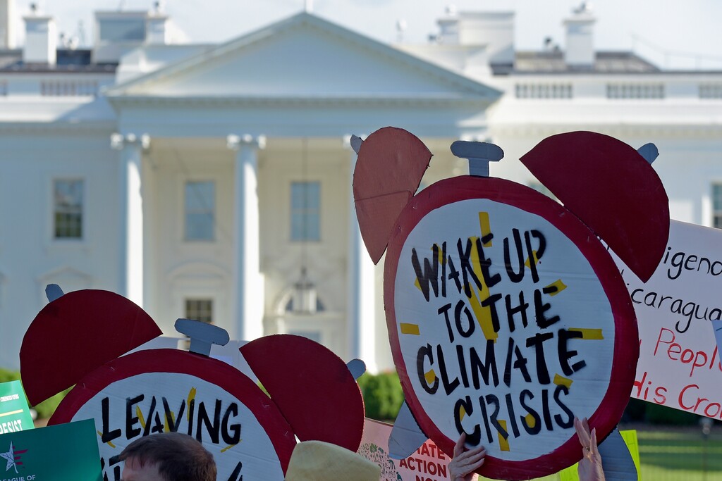 (Susan Walsh | AP) In this June 1, 2017 file photo, protesters gather outside the White House in Washington to protest President Donald Trump's decision to withdraw the Unites States from the Paris climate change accord.