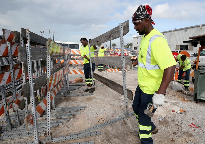 (Jennifer Reynolds | The Galveston County Daily News) Colby Boone, back, and Perry Johnson move barricades and secure equipment in the City of Galveston's traffic yard Thursday, Aug. 24, 2017, as they prepare for severe weather from Hurricane Harvey in Galveston, Texas. The National Hurricane Center is forecasting Harvey will become a major hurricane to hit the middle Texas coastline.
