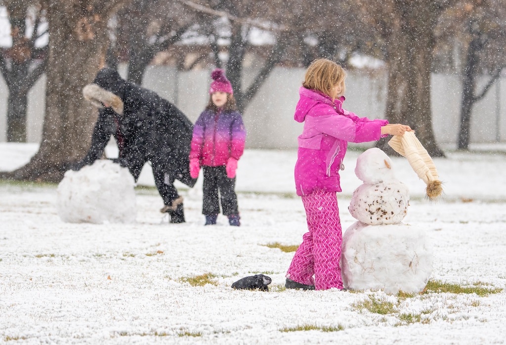 (Leah Hogsten | The Salt Lake Tribune) Two mothers and their children build a snowman in Centerville, Dec. 9, 2021. Not much snow is not expected at lower elevations this week – mostly rain — but 1-2 feet of snow is expected in the mountains.