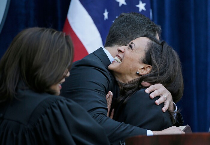 FILE - In this Jan. 5, 2015, file photo, California Attorney General Kamala Harris is embraced by her husband, Douglas Emhoff, after taking the oath of office as state Supreme Court chief justice Tani Cantil-Sakauye looks on at the Crocker Art Museum in Sacramento, Calif. Harris made history Saturday, Nov. 7,  as the first Black woman elected as vice president of the United States, shattering barriers that have kept men — almost all of them white — entrenched at the highest levels of American politics for more than two centuries. (AP Photo/Eric Risberg, File)