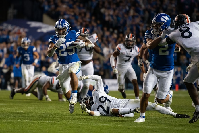 (Trevor Christensen | Special to The Tribune) Brigham Young Universitys Tyler Allgeier breaks a tackle against VirginiaÕs Joey Blount during the second half at LaVell Edwards Stadium on Saturday, Oct. 30, 2021, in Provo.