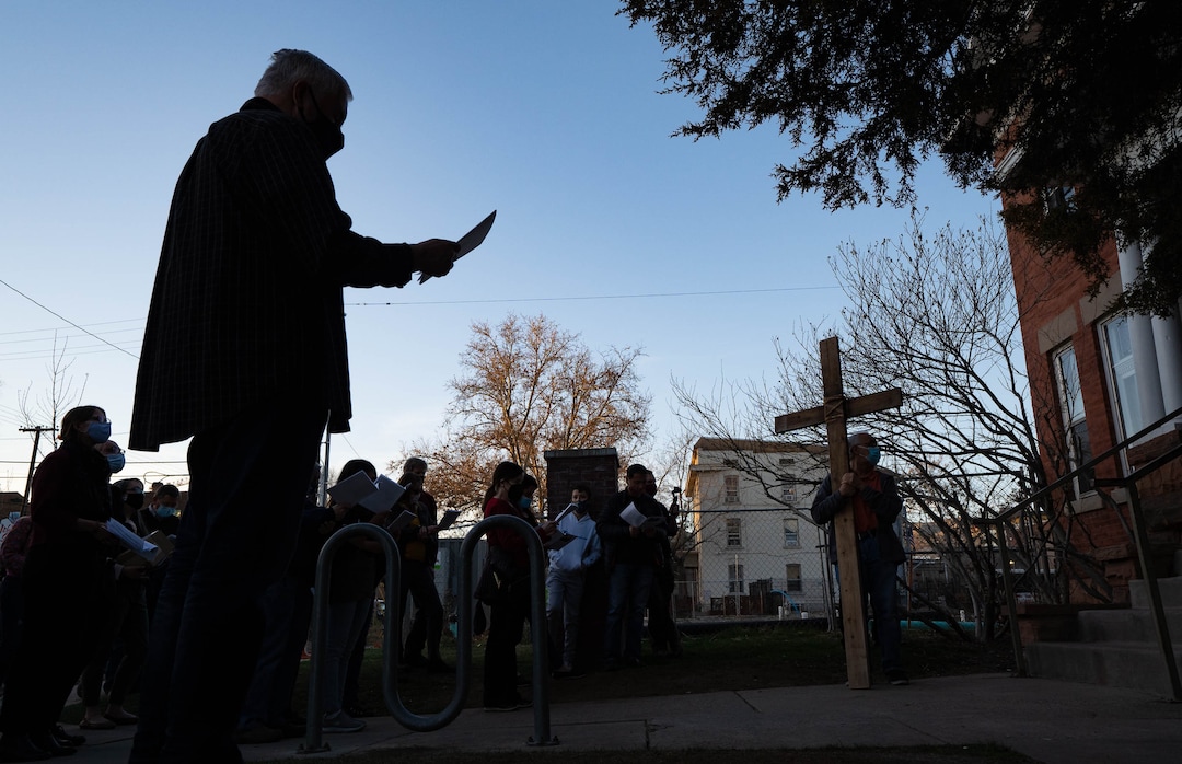 (Francisco Kjolseth  | The Salt Lake Tribune) Mask wearing Utah Christians walk the streets of Salt Lake City beginning at Cathedral of the Madeleine on Good Friday, to symbolically mark Jesus' carrying the cross to his crucifixion, April 2, 2021, as they stop to sing and pray at Crossroads Food Pantry.
