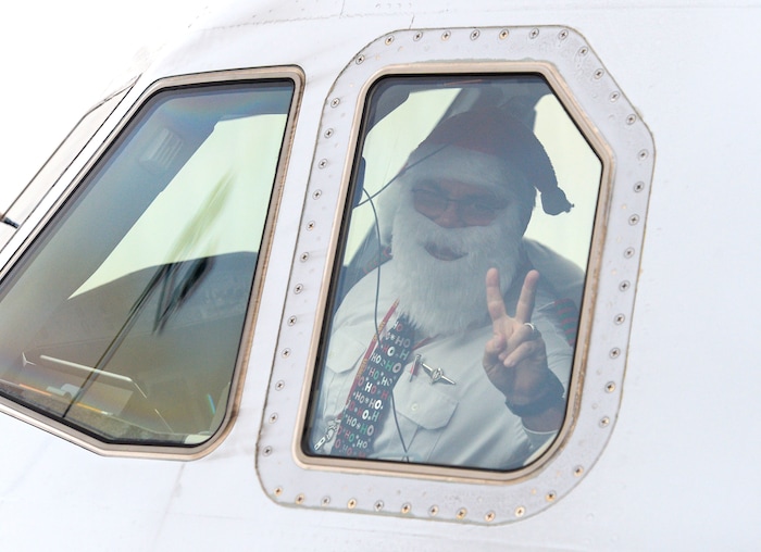 (Leah Hogsten | The Salt Lake Tribune) The American Airlines pilot taking the crew to Orlando waves from the cockpit. Ten Gold Star families from Salt Lake City were treated to a Winter Wonderland scene, including Whoville and the Grinch at their boarding gate at Salt Lake International Airport, Dec. 7, 2019 before their flight to Disney World aboard the Snowball Express. This month, the Gary Sinise Foundation's Snowball Express will fly more than 1,700 family members of fallen U.S. military heroes to Disney World for a holiday retreat.