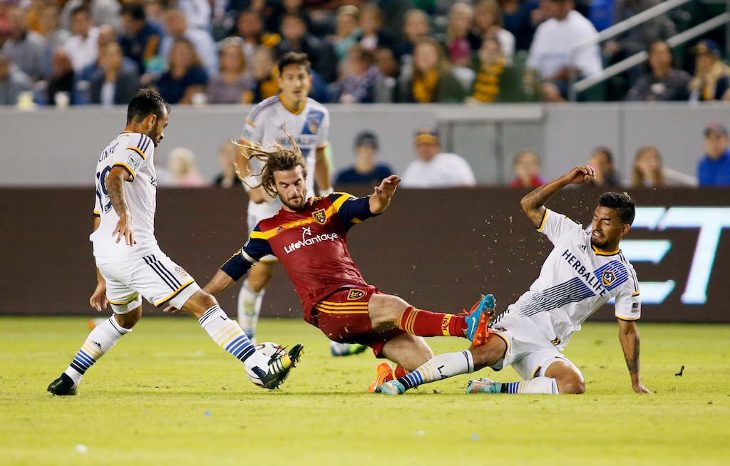 Los Angeles Galaxy's Juninho, left, and A.J. DeLaGarza, right, battle for the ball with Real Salt Lake's Kyle Beckerman, center, during the first half of an MLS soccer Western Conference playoff series game, Sunday, Nov. 9, 2014, in Carson, Calif., Sunday, Nov. 9, 2014. (AP Photo/Danny Moloshok)