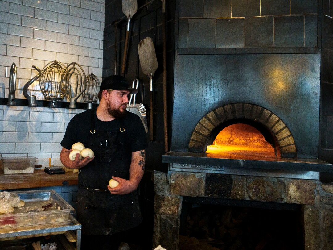 (Leah Hogsten | The Salt Lake Tribune) Sous chef Nathan Price makes prepares dough for orders during Emigration Cafe's opening night, Wednesday, April 27, 2022. Emigration Cafe's menu features Roman style wood fired pizza, salads, sandwiches and mains.
