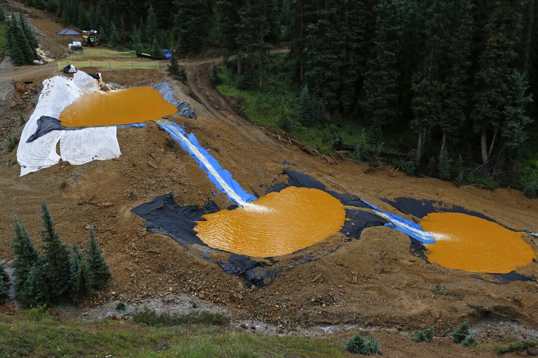 Water flows through a series of retention ponds built to contain and filter out heavy metals and chemicals from the Gold King mine wastewater accident, in the spillway about 1/4 mile downstream from the mine, outside Silverton, Colo., Wednesday, Aug. 12, 2015. The EPA has taken full responsibility for the mine waste spoiling rivers downstream from Silverton, but people who live near the idled and leaking Gold King mine say local authorities and mining companies spent decades spurning federal cleanup help. (AP Photo/Brennan Linsley)