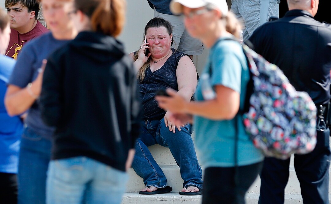 A woman reacts while making a phone call outside the Alamo Gym where parents wait to reunite with their children following a shooting at Santa Fe High School in Santa Fe, Texas, on Friday, May 18, 2018. (Michael Ciaglo/Houston Chronicle via AP)