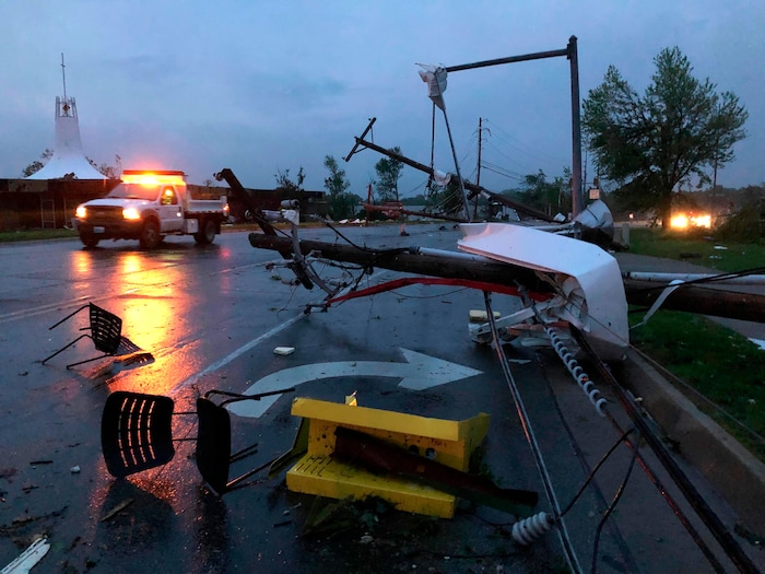 (David A. Lieb | AP) Plastic chairs lie in the road and metal from a damaged gas station roof is twisted around a downed power line in Jefferson City Missouri Thursday, May 23, 2019. The National Weather Service has confirmed a large and destructive tornado has touched down in Missouri's state capital, causing heavy damage and trapping multiple people in the wreckage of their homes.