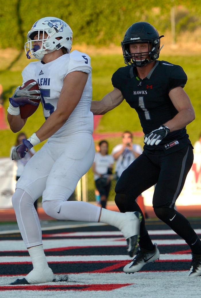 (Leah Hogsten  |  The Salt Lake Tribune) Lehi's Dallin Holker catches the touchdown pass in the first half. Alta's Zach Engstrom is at right. Holker caught two touchdown passes. Lehi High School leads Alta High School 42-28 during their game, Friday, August 18, 2017 in Sandy. 