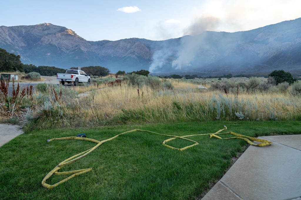 (Benjamin Zack | Special to The Tribune) Homes and fire hoses near the Willard Peak Fire near North Ogden on Thursday, Aug. 14, 2025.