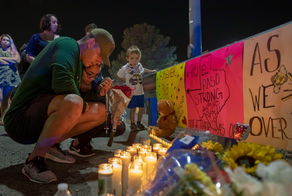 (Andres Leighton | AP Photo) Rene Aguilar and Jackie Flores pray at a makeshift memorial for the victims of Saturday's mass shooting at a shopping complex in El Paso, Texas, Sunday, August 4, 2019.