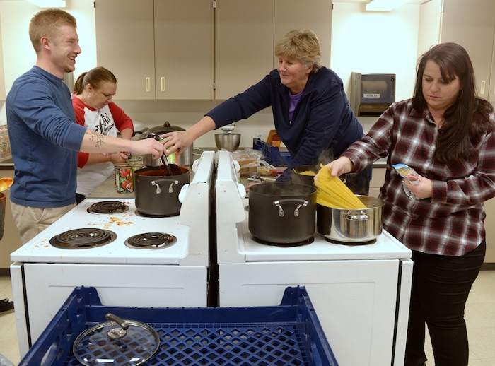 (Leah Hogsten  |  The Salt Lake Tribune) l-r Granite Park Junior High after school coordinator Carter Woolf shares a laugh with physical education and health teacher and sports coach Lori Vreeken (center) and history teacher Emily Mijarez as they cook dinner for their students and their family. Sixteen members of Granite Park Junior High SchoolÕs faculty prepared and served a hot spaghetti meal to students and their families, Friday, December 22, 2017 at the school for the inaugural ÔDinner at the Park.' Roughly 90 percent of students who attend Granite Park Junior High in South Salt Lake qualify for free or reduced lunch through the federal school lunch program. Knowing the challenges faced by their students, staff members at Granite Park came up with an idea to help families through the holidays.