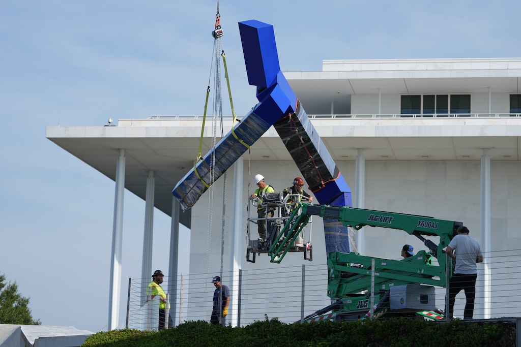 Workers remove the sculpture "Blue" by artist Joel Shapiro on the grounds of the John F. Kennedy Center for the Performing Arts in Washington, Wednesday, Sept. 2, 2026. (AP Photo/Mark Schiefelbein)