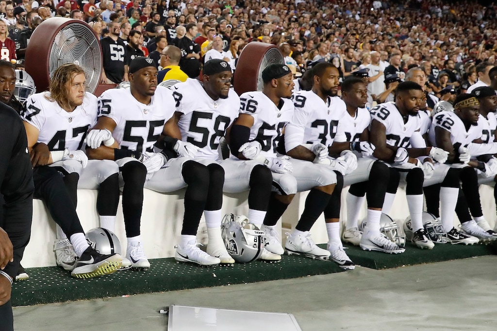 James Cowser (47) of the Oakland Raiders, locks arms with teammates during the playing of the National Anthem before an NFL football game against the Washington Redskins in Landover, Md., Sunday, Sept. 24, 2017. (AP Photo/Alex Brandon)