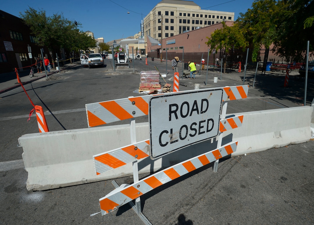 (Steve Griffin  |  The Salt Lake Tribune) Workers cement  fence posts into position on Rio Grande Street in Salt Lake City Monday September 11, 2017.