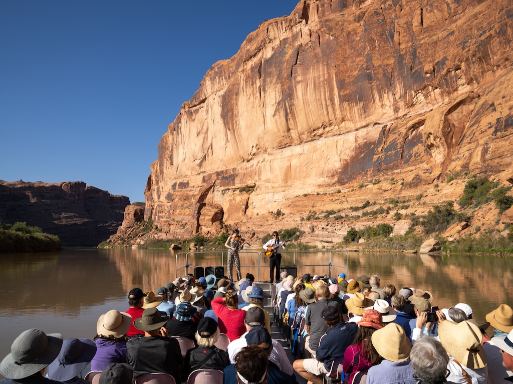 (Niki Chan Wylie | The New York Times) Violinist Tessa Lark and the guitarist Frank Vignola perform on the Colorado River in Moab, Utah, on Sept. 7, 2025. The Moab Music Festival offers some of the purest, most intense listening experiences around. But what happens when its signature river dries up?