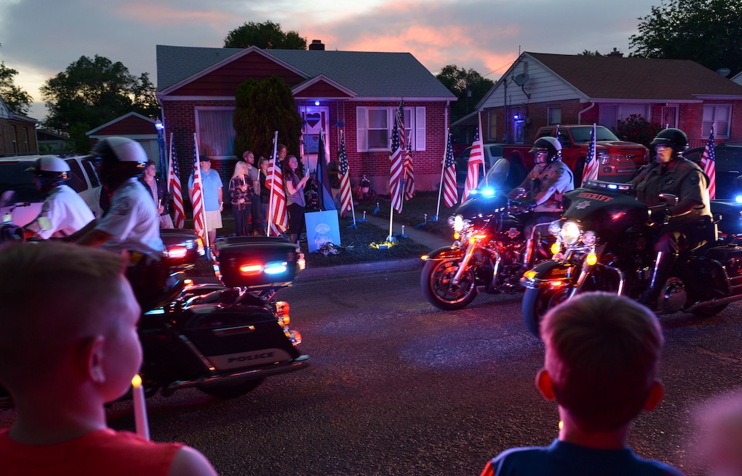 (Leah Hogsten  |  The Salt Lake Tribune) Ogden Police Department vehicles drive past Officer Nate Lyday's childhood home on Custer Avenue in Ogden in a Memorial Procession and Community Vigil in honor of Lyday's life. The procession made its way through five other Ogden landmarks before ending at Lindquist Field.
