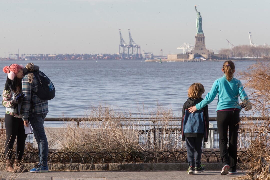 Visitors to the Statue of Liberty take in the sight from battery park, Saturday, Jan. 20, 2018, in New York. The National Park Service announced that the Statue of Liberty and Ellis Island would be closed Saturday "due to a lapse in appropriations." Late Friday, the Senate failed to approve legislation to keep the government from shutting down after the midnight deadline. (AP Photo/Mary Altaffer)
