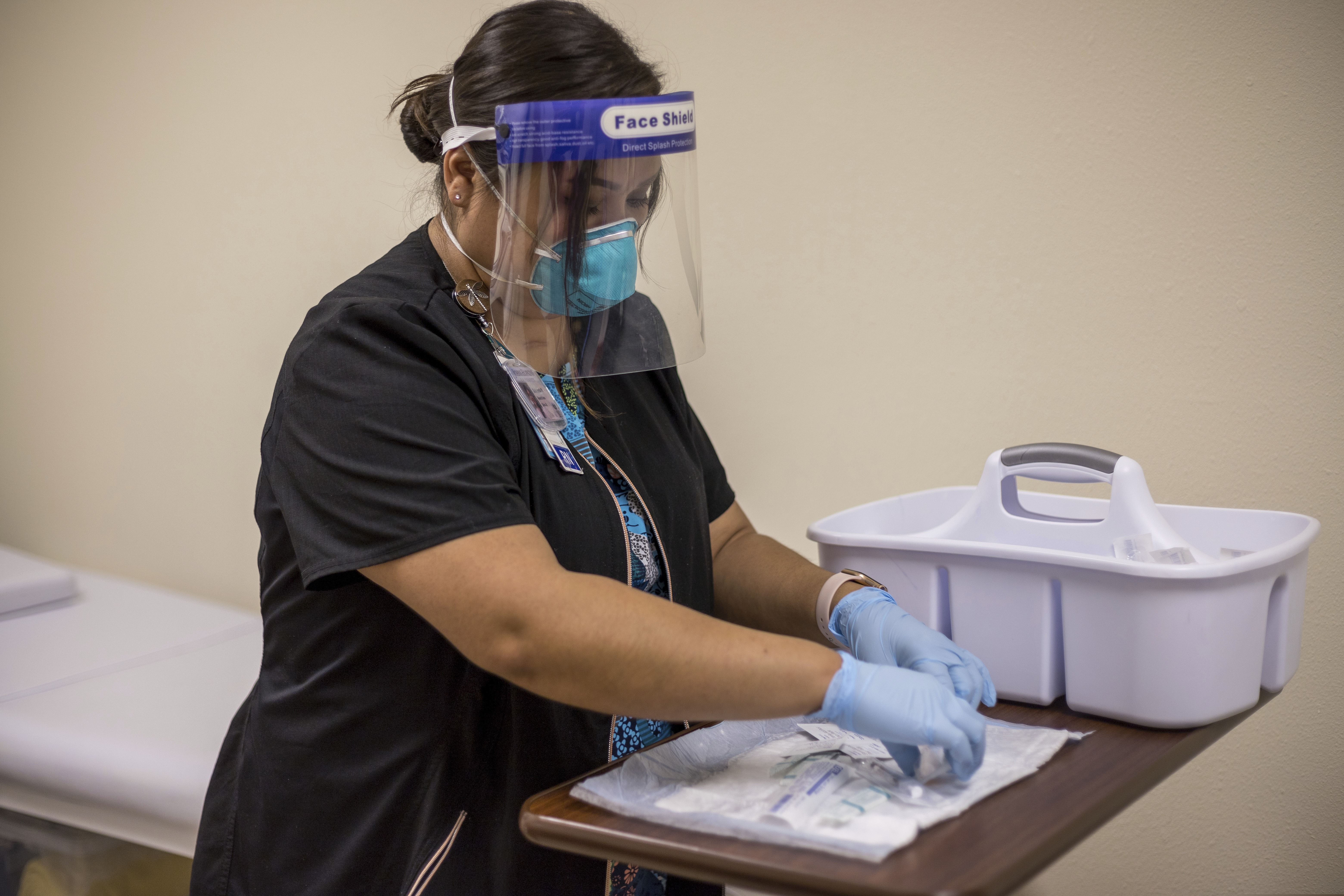 (Nina Mayer Ritchie/Johns Hopkins Center for American Indian Health via AP) On Dec. 29, 2020, registered nurse Starla Garcia prepares a coronavirus vaccine in Chinle, Ariz., for someone who enrolled in the COVID-19 vaccine trials on the Navajo Nation and initially received a placebo.