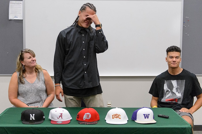 (Trent Nelson  |  The Salt Lake Tribune)  Olympus tight end Cameron Latu announces he's headed to Alabama during a news conference at Olympus High School in Salt Lake City Friday August 4, 2017. His mother Jill Argust at left, and brother Nate Latu at right.