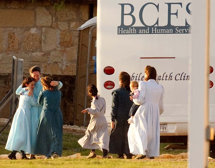 (Trent Nelson | The Salt Lake Tribune)
San Angelo, Texas - Janet, an FLDS matriarch, tearfully embraces young girls as they arrive at the old historic Fort Concho, where nearly 500 FLDS women and children would be temporarily sheltered in primitive buildings such as former horse barns. The large amount of people that Texas Child Protective Services called victims overwhelmed the state's foster care system.
