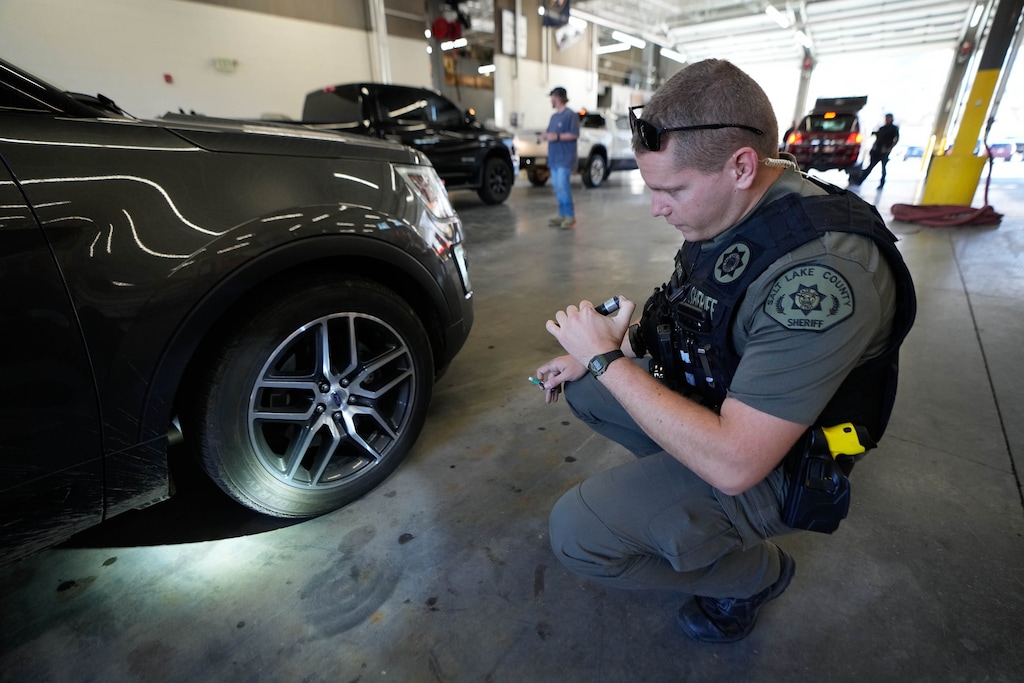 (Francisco Kjolseth | The Salt Lake Tribune) Deputy Aaron Weiner with the Salt Lake County Sheriff’s office checks a tire for a mud and snow standard during a free sticker distribution kick-off event that expands new traction law requirements for the Cottonwood Canyons on Thursday, Nov. 13, 2025.