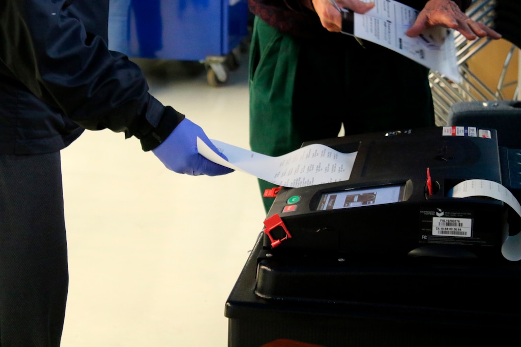 (Noreen Nasir | AP) Voters cast their ballots during early voting in Chicago while wearing protective gloves on Saturday, March 14, 2020. Residents and poll workers took extra precautions amid concerns over the coronavirus. The Illinois state primary elections are scheduled for Tuesday, March 17.