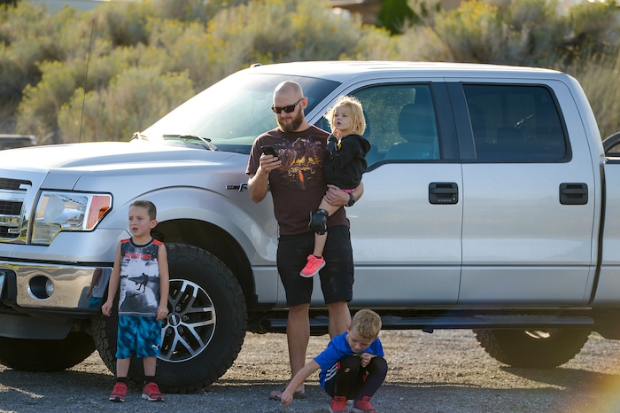 Leah Hogsten  |  The Salt Lake Tribune   Danny Hill and his children l-r Zac, 6, Owen, 5, and Leah, 2, watch as a helicopter gets water from Herriman Cove pond and wait for mom to call them home for dinner. Homeowners who were not allowed to return to their homes and onlookers waited near Herriman Cove pond to watch as a firefighting helicopter refilled. A 50-acre wildfire in Rose Canyon was threatened about a half-dozen homes Wednesday, Sept. 12, 2018. A spokesman for Unified Fire said the blaze has already burned a few structures, including outhouses and sheds. Firefighters have evacuated around 20 to 30 homes in two neighborhoods near 15555 S. Rose Canyon Road in Herriman. 