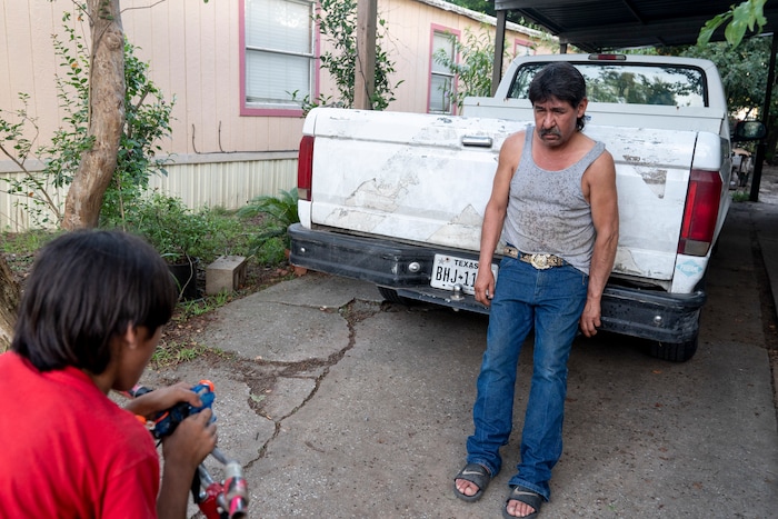 (Ilana Panich-Linsman | The New York Times) Noe Rodriguez, 9, uses a handlebar-mounted squirt gun to cool down his father, Candelario Rodriguez, in Houston, July 23, 2020. Around the world, the poor and marginalized are much more likely to be vulnerable to extreme heat; three of Candelario's co-workers have collapsed from heat exhaustion over the years.