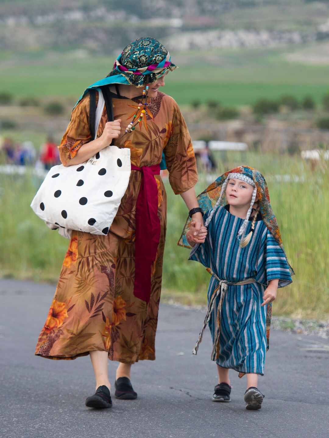 (Rick Egan  |  The Salt Lake Tribune)    Audrey Wendel and 4-year-old Lydia Wendel, from Bountiful, dressed as Nephites, make their way down the hill to visit whith the audience, at the Manti Temple for the Mormon Miracle Pageant Wednesday, June 12, 2019.  The final run for the pageant continues through Saturday, June 22.