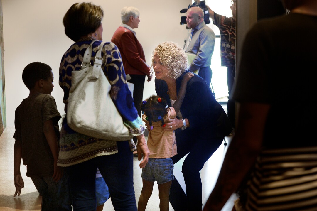 (Scott Sommerdorf   |  The Salt Lake Tribune)   Salt Lake City Mayor Jackie Biskupski reaches down to pick up a member of the Tillman family who had come to the VOA, Utah Homeless Youth Resource Center to visit a family member. Mayor Biskupski was there to speak at a press conference where it was announced that Gail Miller and the Miller family after had made a challenge grant of up to 10 million dollars to fund future homeless programs and services at the VOA, Utah Homeless Youth Resource Center, Thursday, August 17, 2017. 
