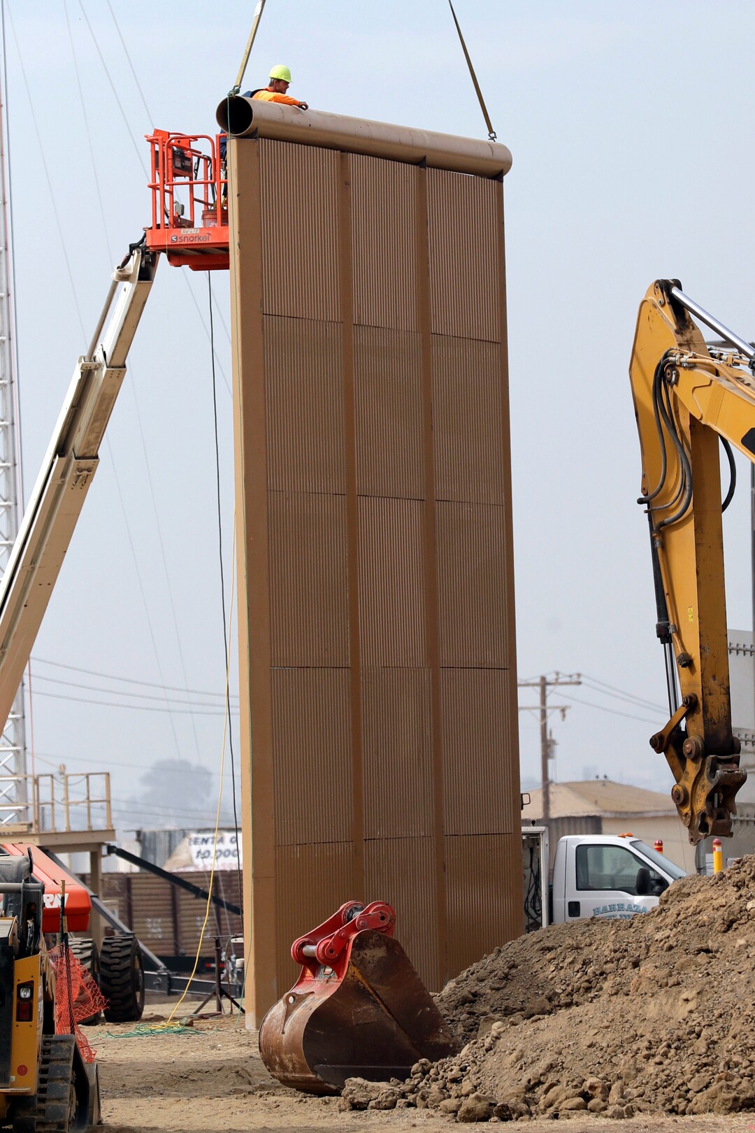 (Gregory Bull | Associated Press file photo)  In this Oct. 19, 2017 file photo, crews work on a border wall prototype near the border with Tijuana, Mexico, in San Diego. A U.S. official says recent testing of prototypes of President Donald Trump's proposed wall with Mexico found their heights should stop border crossers. U.S. tactical teams spent three weeks trying to breach and scale the models in San Diego. An official with direct knowledge of the results said they point to see-through steel barriers topped by concrete as the best design. The official spoke to The Associated Press on condition of anonymity because the information is not authorized for release.
