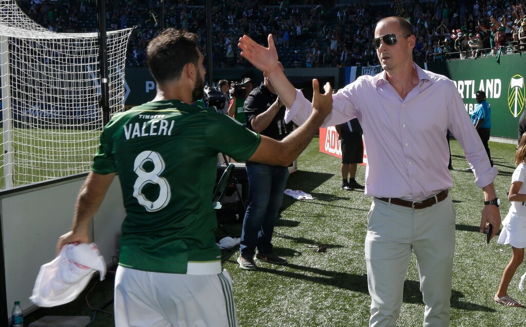 Portland Timbers owner Merritt Paulson, right, greets Timbers midfielder Diego Valeri (8) after the Timbers beat the Seattle Sounders 4-2 in an MLS soccer match, Sunday, Aug. 28, 2016, in Portland, Ore. (AP Photo/Ted S. Warren)