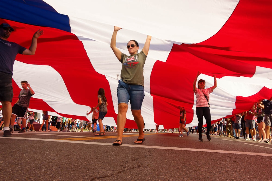 (Trent Nelson | The Salt Lake Tribune)  The Days of '47 Parade in Salt Lake City, Tuesday July 24, 2018. Volunteers carry a large flag.