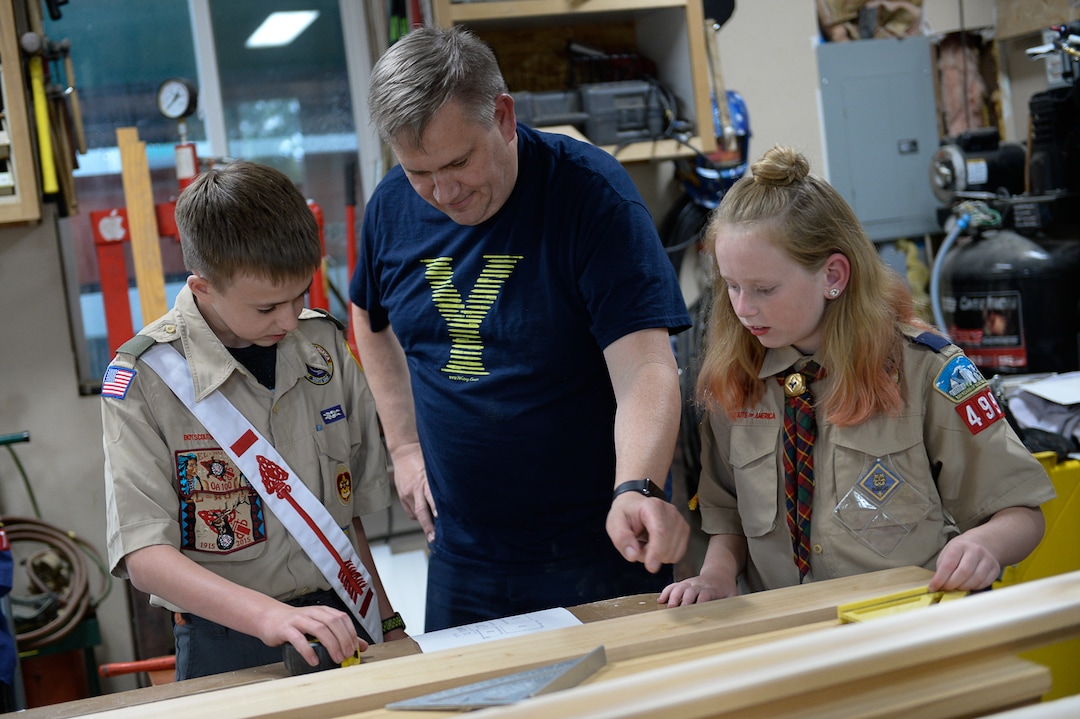 (Francisco Kjolseth  |  The Salt Lake Tribune)  Darwin Cook, Deseret Peak District Chair with the Boy Scouts of America offers guidance to his son Kolbie as he works on his Eagle Scout merit badge with a little help from his sister Miriam in the family garage in Tooele on Monday, May 14, 2018. Miriam is an early adopter into the Cub Scouts, always having expressed an interest in what her brother is doing as they assemble bird houses for a golf course. 