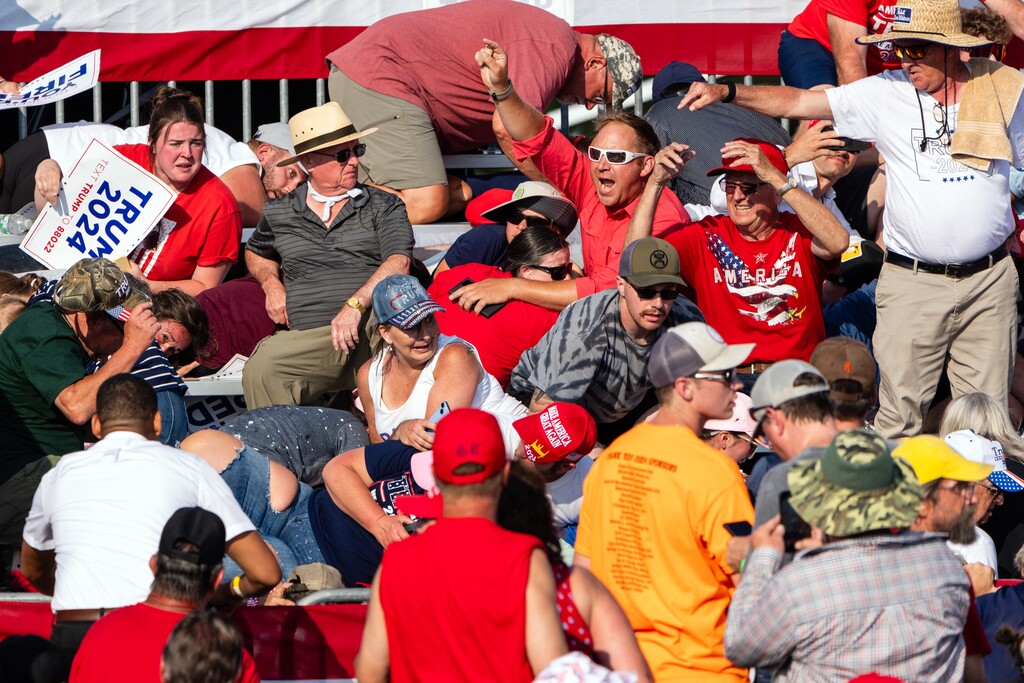 (Eric Lee | The New York Times) Supporters of former President Donald Trump frantically try to attract aid for a victim injured in the shooting at a campaign rally in Butler, Pa., on Saturday, July 13, 2024.