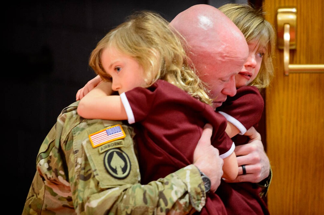 (Trent Nelson | The Salt Lake Tribune)  Captain Tyler Boyle embraces his daughters Avery, right, and Alexis in Draper on Wednesday Jan. 2, 2019. Tyler is one of eighteen Utah National Guard soldiers who are deploying to Fort Meade, Maryland, for 400 days to conduct cyber protection operations.