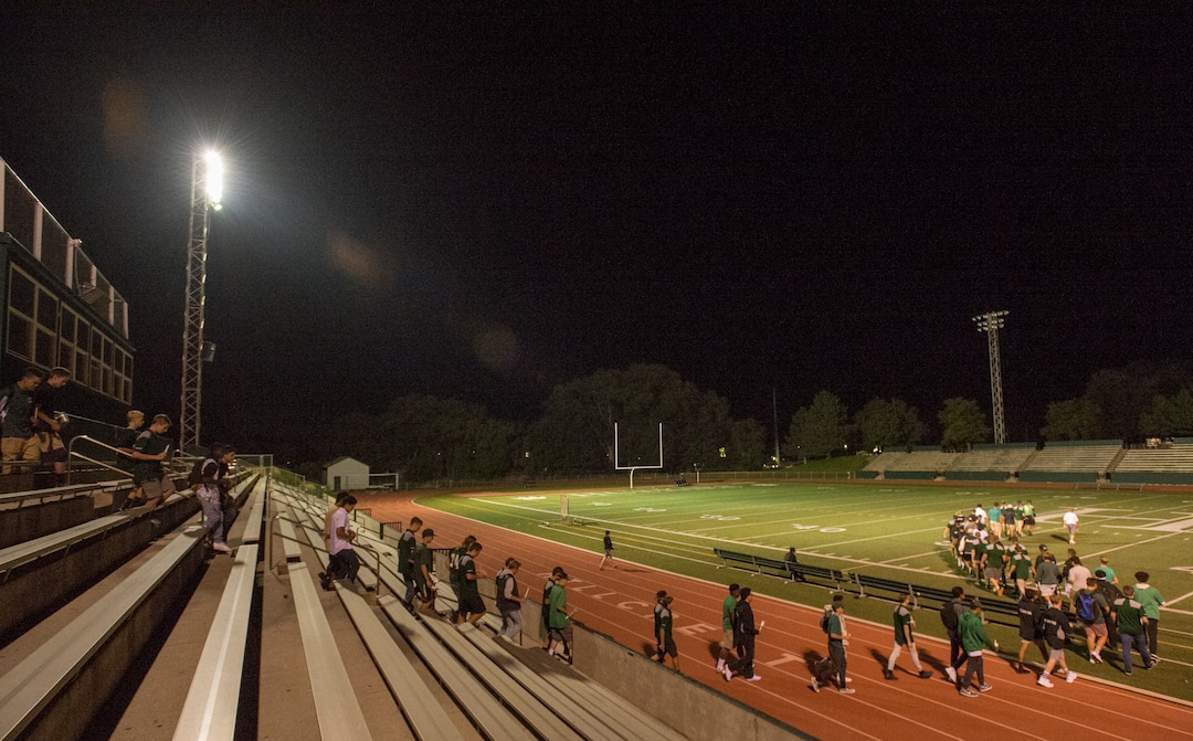 (Rick Egan  |  The Salt Lake Tribune)The Hillcrest football team walks onto the field for a candlelight vigil in honor of coach Cazzie Brown, at Hillcrest High School, Monday, August 28, 2017.