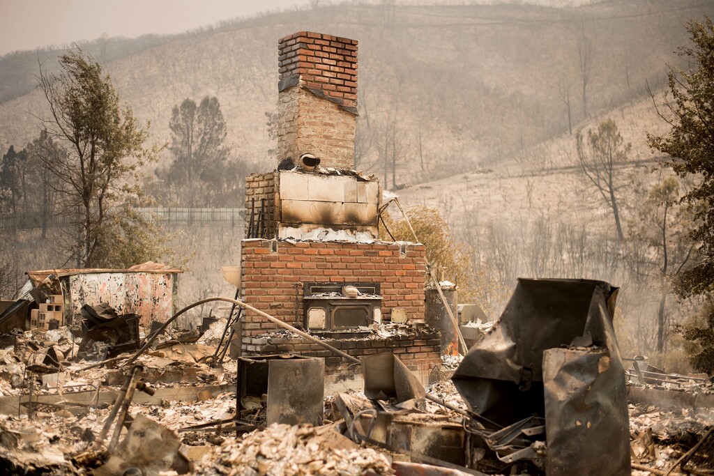 A chimney stands at a burned residence on Yaqui Gulch Road as a wildfire burns near Mariposa, Calif., on Wednesday, July 19, 2017. The fire has forced more than 4,000 people from homes in and around a half-dozen small communities, officials said (AP Photo/Noah Berger)