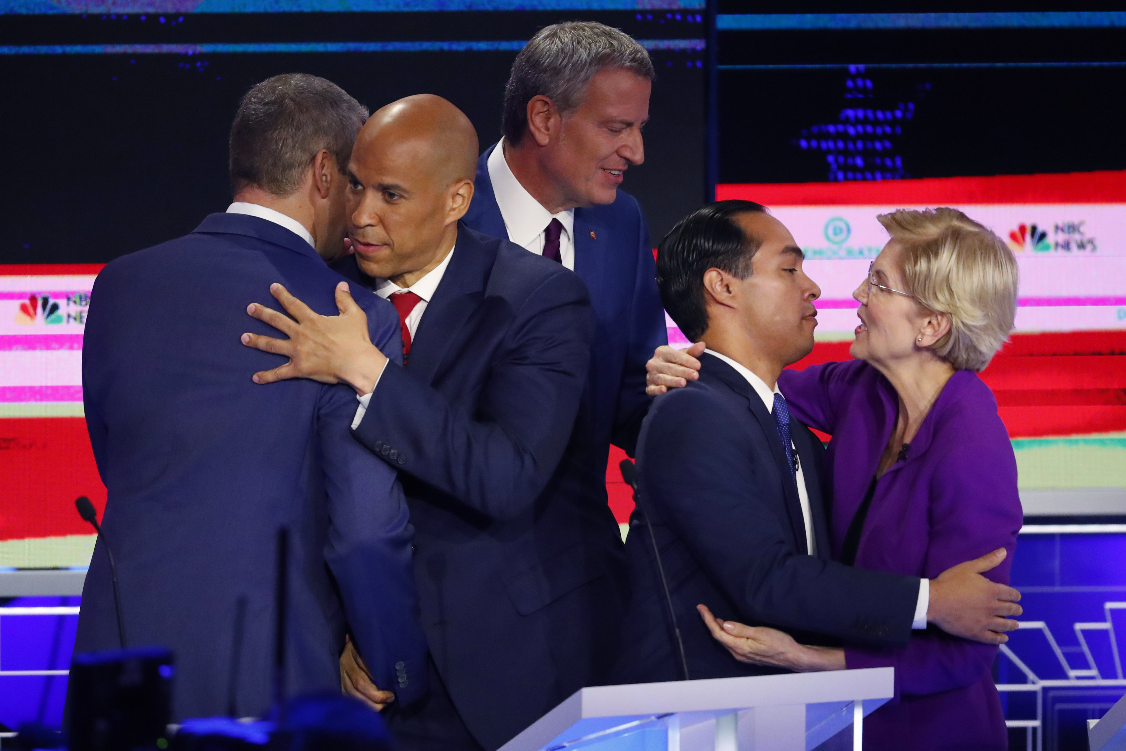 Democratic presidential candidate Sen. Cory Booker, D-N.J., second from left, hugs Rep. Tim Ryan, D-Ohio, while Sen. Elizabeth Warren, D-Mass., hugs former Housing and Urban Development Secretary Julian Castro at the end of a Democratic primary debate hosted by NBC News at the Adrienne Arsht Center for the Performing Arts, Wednesday, June 26, 2019, in Miami. In between them is New York City Mayor Bill de Blasio. (AP Photo/Wilfredo Lee)