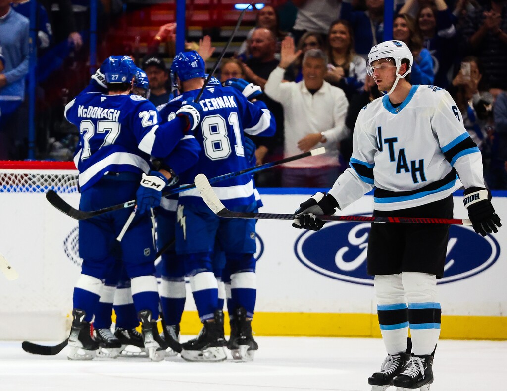 (Dirk Shadd | Tampa Bay Times) Tampa Bay Lightning players celebrate the goal score by right wing Oliver Bjorkstrand (22) as Utah Hockey Club defenseman John Marino (6) skates off during second period action at Amalie Arena on Thursday, March 27, 2025 in Tampa, Fla.