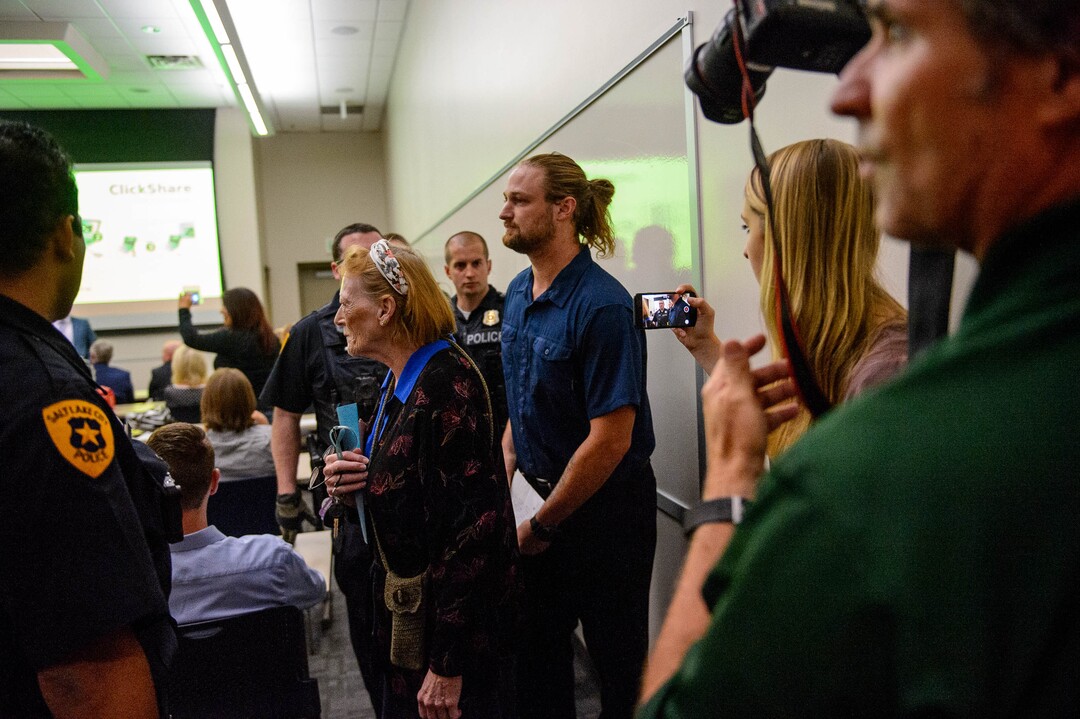 (Trent Nelson  |  The Salt Lake Tribune)  
Ethan Peterson argues with police who are removing him from a meeting of an inland port satellite working group held at a police precinct in Salt Lake City on Wednesday, Aug. 14, 2019. At front is Jill Merritt. The meeting was quickly canceled soon after it began.
