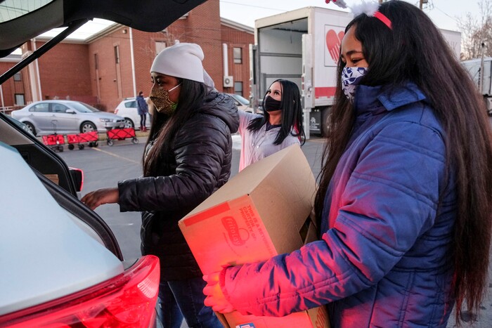 (Leah Hogsten | The Salt Lake Tribune) Volunteers Leilani Vatuvei, left and her sister Eime Vatuvi help hand out food from the Utah Food Bank to needy families, Dec. 23, 2020.