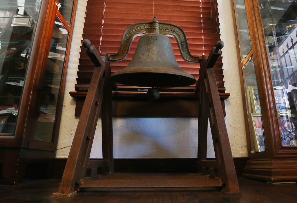 In this Friday, Dec. 28, 2018 photo, a bell that once hung at a Lees Ferry, Ariz., school, the small settlement where pioneers crossed the Colorado River on ferry barges, is shown on display at a local office in Phoenix. The bell is to be the focal point of a proposed memorial honoring the tens of thousands of Arizonans who trace their roots in the state back to a mass migration of Mormon settlers, who made the journey from Utah over a century ago, crossing the river at Lees Ferry, in their months-long journey, before a bridge was built at the crossing in 1929. (AP Photo/Ross D. Franklin)