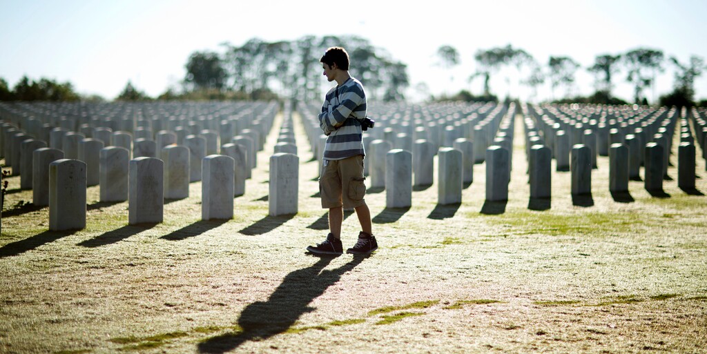 A visitor at the South Florida National Cemetery walks among veterans' graves on Veterans Day in Lake Worth, Fla., Tuesday, Nov. 11, 2014.  (AP Photo/J Pat Carter)