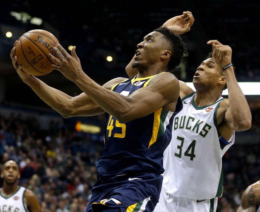 Utah Jazz's Donovan Mitchell, left, attempts to shoot while being defended by Milwaukee Bucks' Giannis Antetokounmpo during the second half of an NBA basketball game Saturday, Dec. 9, 2017, in Milwaukee. (AP Photo/Aaron Gash)