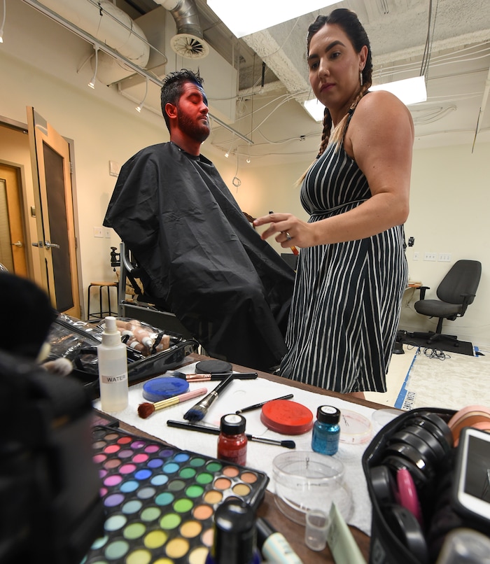 (Francisco Kjolseth | The Salt Lake Tribune) Makeup artist Kristen Packard works her magic on Brad Klekas of South Jordan, a BYU and Utah fan alike as he's willing to show his mutual admiration of both teams by stepping into the Tribune studio to get both colors in anticipation of the upcoming match up between the two rival teams on Saturday.