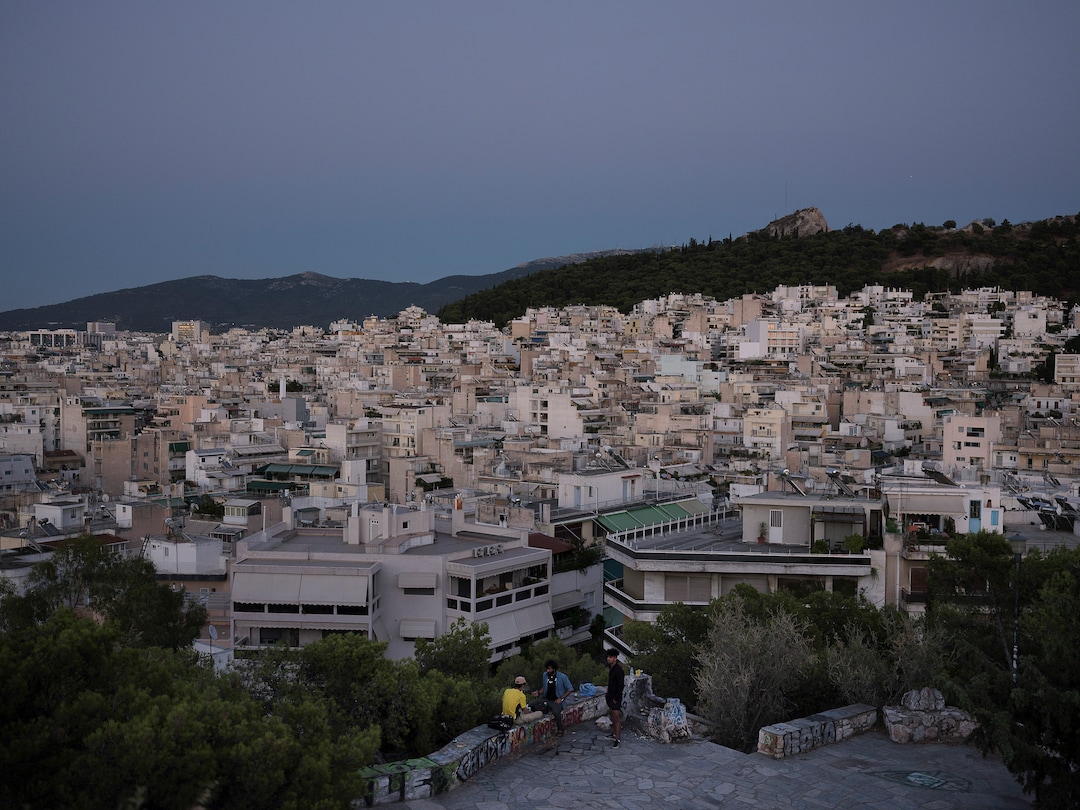 (Myrto Papadopoulos | The New York Times) Hasib Hotak, a homeless refugee from Afghanistan, and friends pass an evening in a park in Athens, Greece, July 22, 2020. Around the world, the poor and marginalized are much more likely to be vulnerable to extreme heat; Hasib has been sleeping on a rooftop that turns blazing hot by midday.
